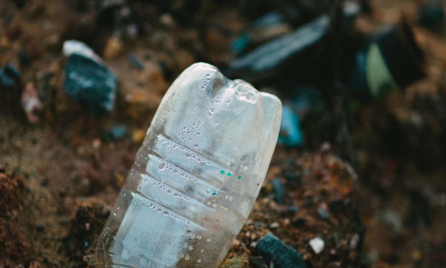 botella de plástico medio enterrada en el suelo